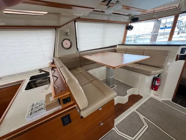 Slide: The Image of 2019 Ranger Tugs R-41 CB interior with dining area and beige seating. - 16