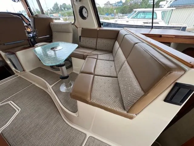 Slide: The Image of Interior of 2019 Ranger Tugs R-41 CB with plush seating and glass table. - 17