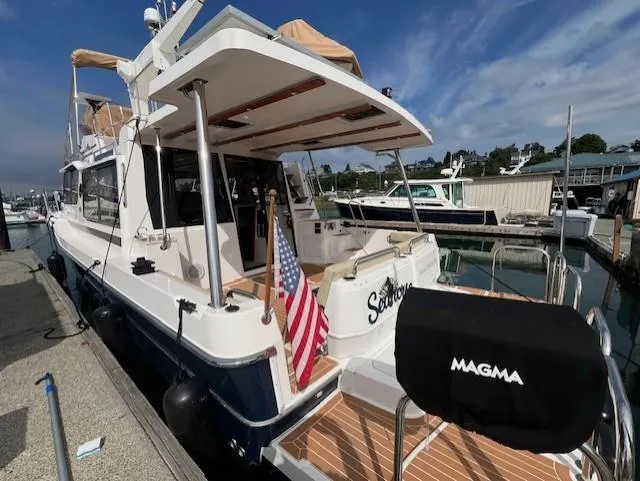 Slide: The Image of 2019 Ranger Tugs R-41 CB docked, featuring spacious deck and American flag. - 3