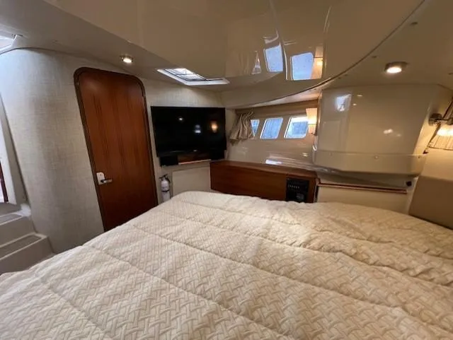 Slide: The Image of 2019 Ranger Tugs R-41 CB cabin interior with bed, TV, and wooden door. - 34