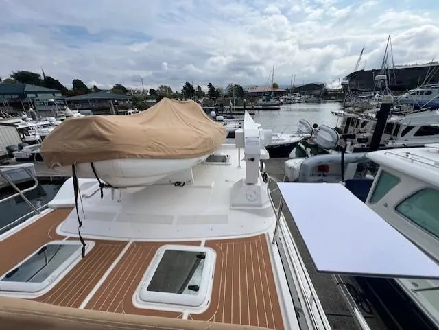 Slide: The Image of 2019 Ranger Tugs R-41 CB yacht docked at a marina, featuring a covered upper deck. - 47