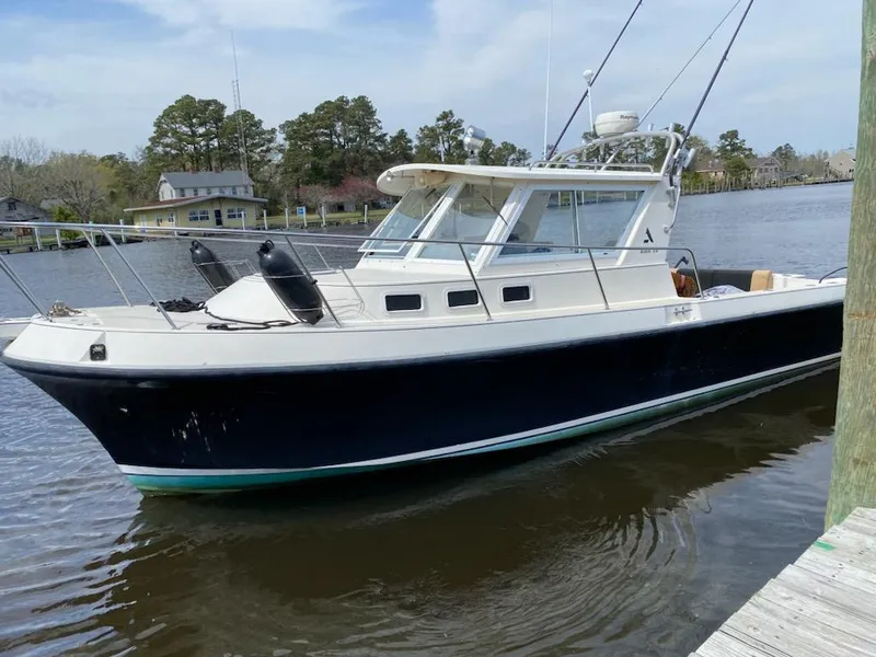 Slide: The Image of 1995 Albin 28 Tournament Express boat docked on a calm river. - 1