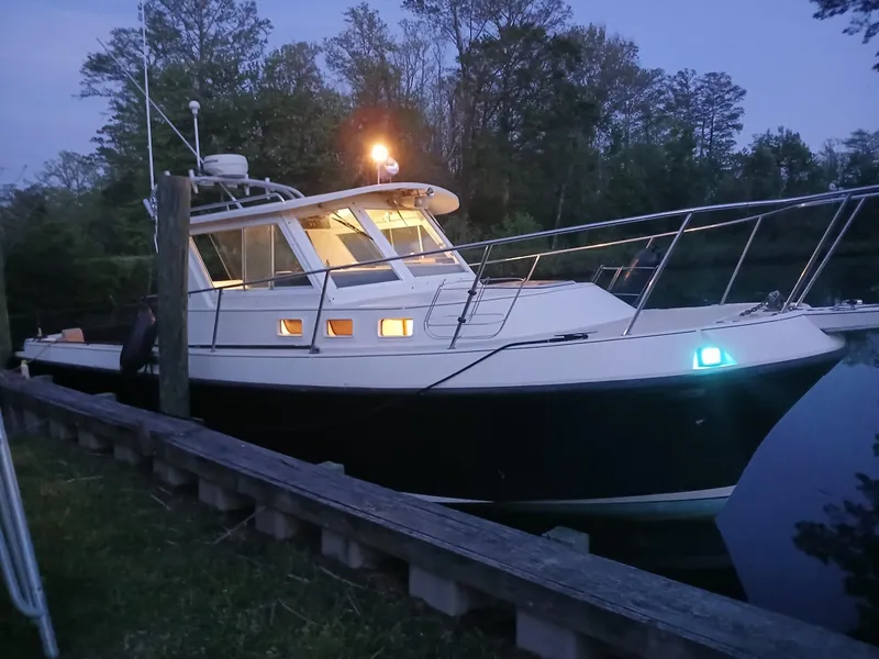Slide: The Image of 1995 Albin 28 Tournament Express boat docked at dusk with lights on. - 2