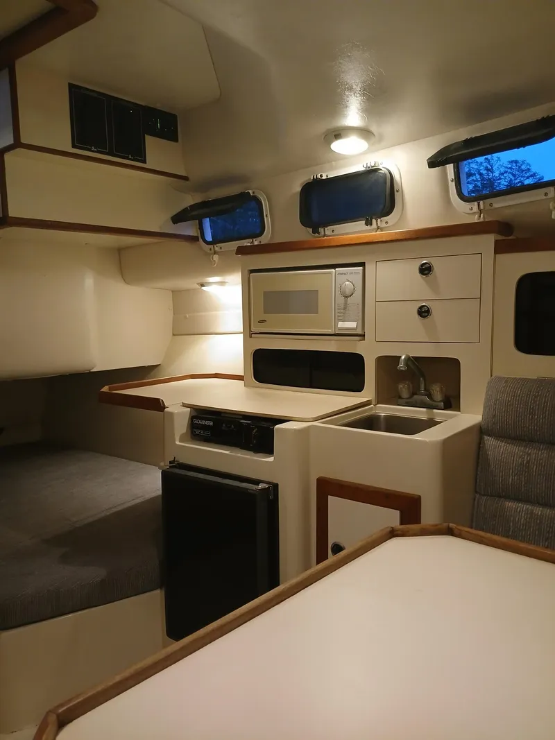 Slide: The Image of Interior of 1995 Albin 28 Tournament Express boat with kitchenette and seating area. - 3