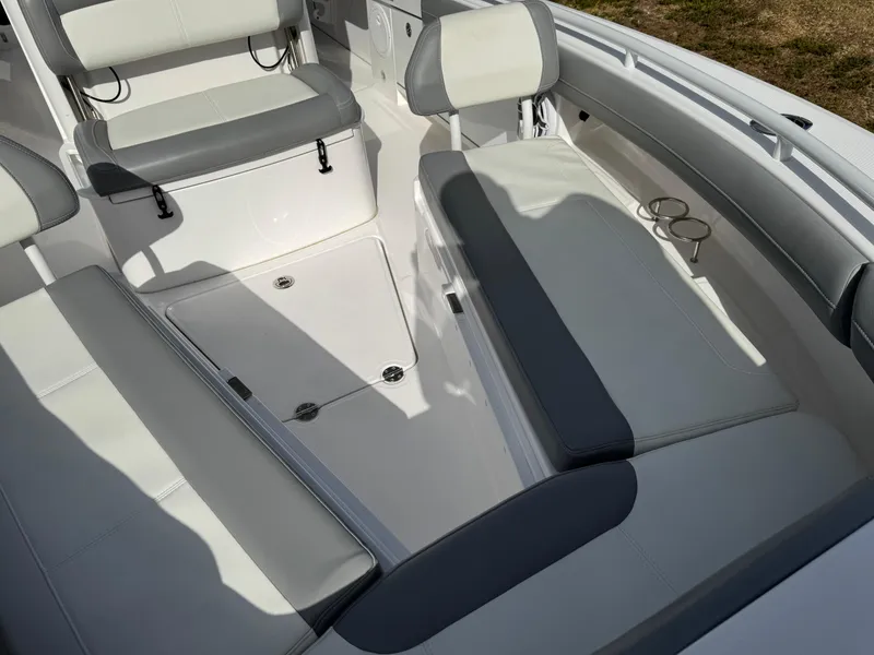 Slide: The Image of 2024 Everglades 253 Center Console boat interior with cushioned seating and cup holders. - 14