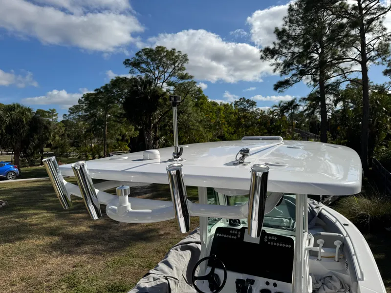 Slide: The Image of 2024 Everglades 253 Center Console boat with rod holders, set against a scenic outdoor backdrop. - 24