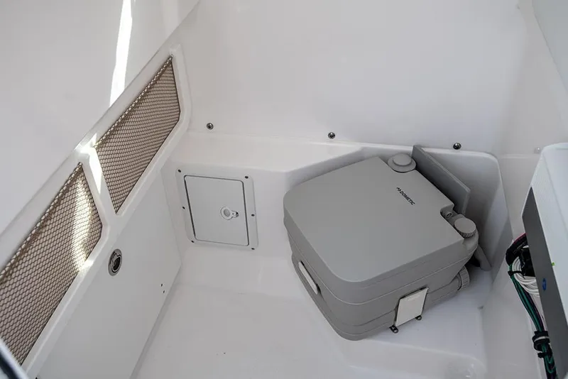 Slide: The Image of 2024 Everglades 253 Center Console interior with portable toilet and storage compartments. - 29