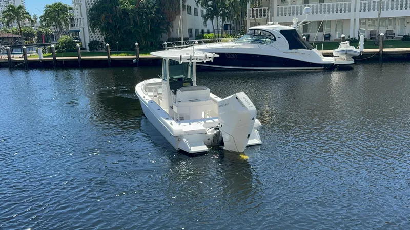 Slide: The Image of 2024 Everglades 253 Center Console boat on calm water near a dock. - 3