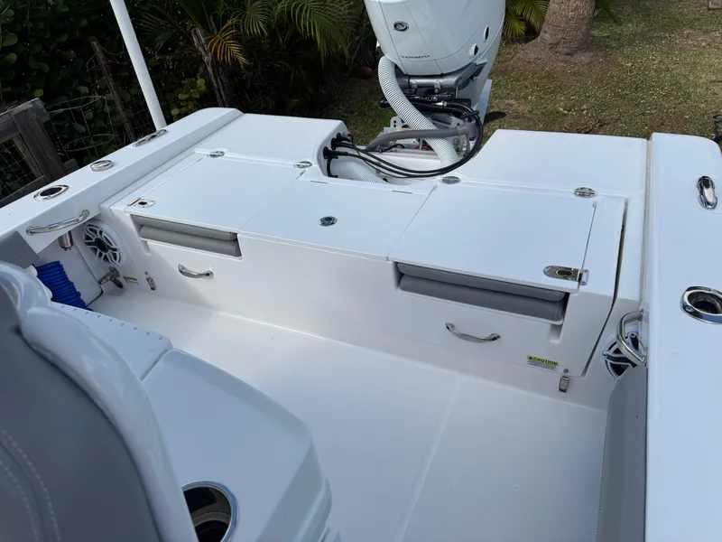 Slide: The Image of 2024 Everglades 253 Center Console boat deck with storage compartments and motor. - 35