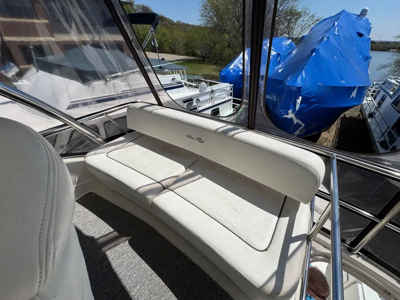 Slide: The Image of 2005 Sea Ray 500 Sedan Bridge interior with white seating and marina view. - 14