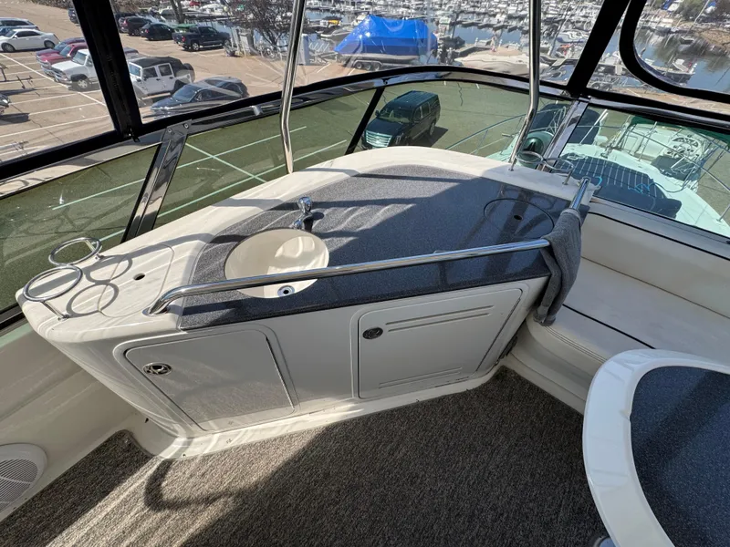 Slide: The Image of 2005 Sea Ray 500 Sedan Bridge interior with sink and seating area, overlooking marina. - 22