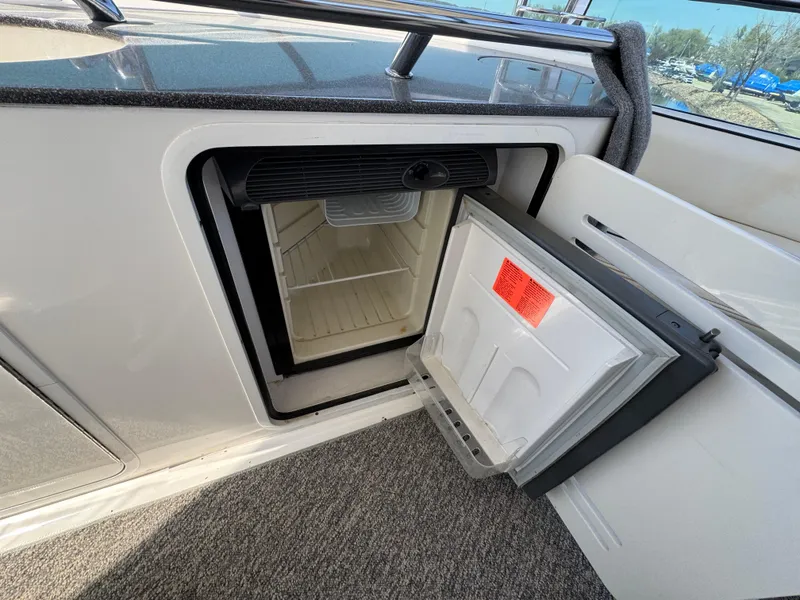 Slide: The Image of Open mini fridge on 2005 Sea Ray 500 Sedan Bridge yacht, showcasing interior storage space. - 25
