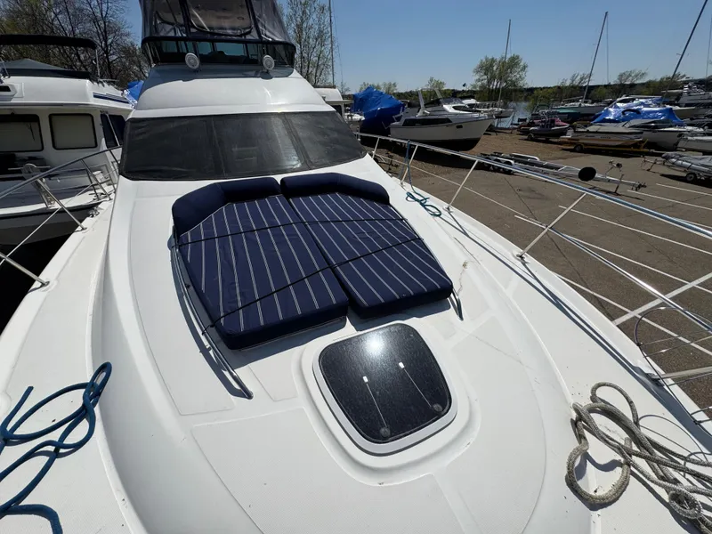 Slide: The Image of 2005 Sea Ray 500 Sedan Bridge yacht with sun pads on deck, docked at marina. - 28