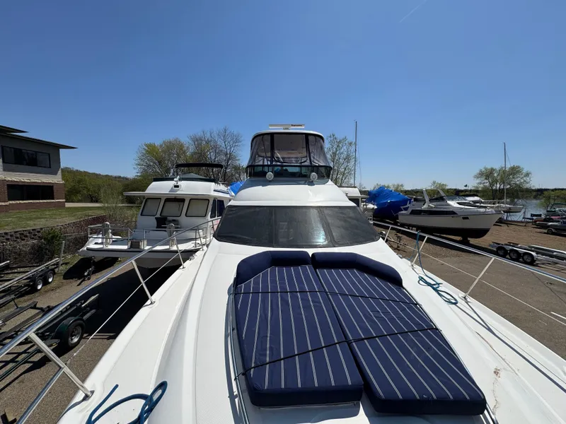 Slide: The Image of 2005 Sea Ray 500 Sedan Bridge yacht with sun pads, docked alongside other boats. - 29