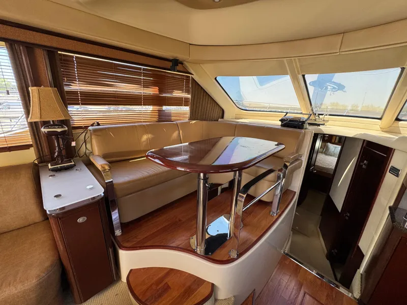 Slide: The Image of Interior of 2005 Sea Ray 500 Sedan Bridge yacht with elegant seating and wooden table. - 43