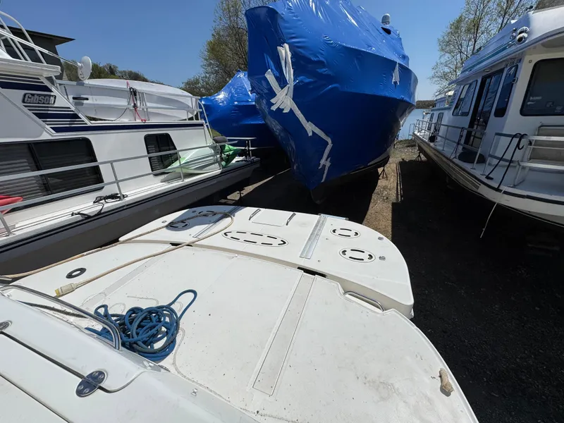 Slide: The Image of 2005 Sea Ray 500 Sedan Bridge yacht docked, covered in blue tarp, surrounded by other boats. - 6