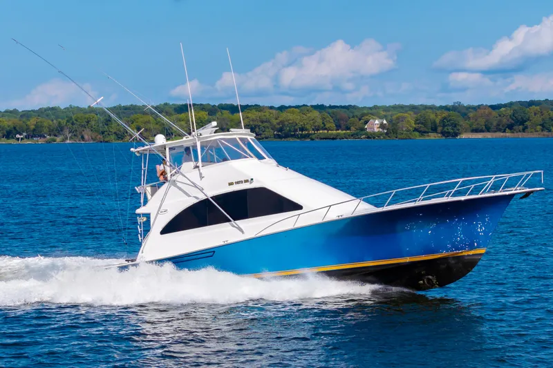 Slide: The Image of 2005 Ocean Yachts Super Sport cruising on blue water under a clear sky. - 10