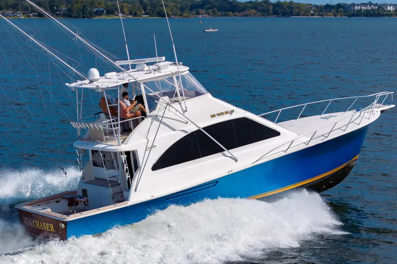 Slide: The Image of 2005 Ocean Yachts Super Sport cruising on open water, showcasing sleek design and vibrant blue hull. - 3