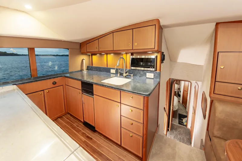 Slide: The Image of Luxurious 2005 Ocean Yachts Super Sport kitchen interior with wood cabinets and ocean view. - 31