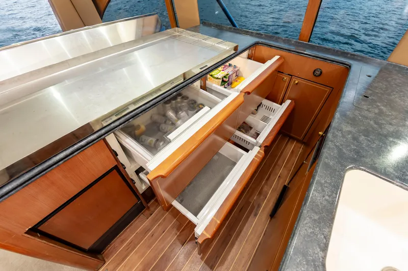 Slide: The Image of 2005 Ocean Yachts Super Sport kitchen with open drawers, wooden flooring, and ocean view. - 33