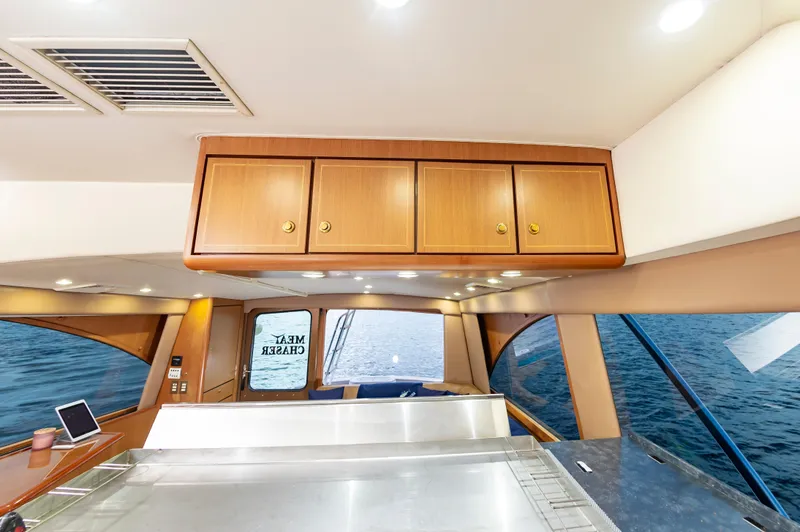 Slide: The Image of Interior of 2005 Ocean Yachts Super Sport, featuring wooden cabinets and ocean view. - 36