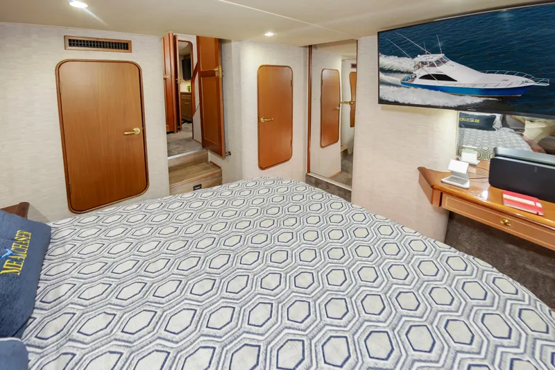 Slide: The Image of Luxurious 2005 Ocean Yachts Super Sport bedroom interior with patterned bedding and wooden accents. - 40