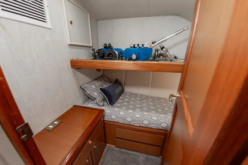 Slide: The Image of 2005 Ocean Yachts Super Sport cabin with bed, storage, and fishing equipment. - 49