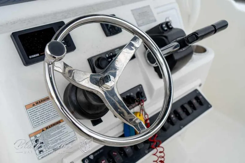 Slide: The Image of Steering wheel and controls of a 2017 Century 2600 boat. - 13
