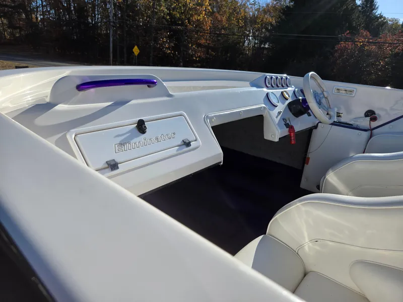Slide: The Image of 2000 Eliminator 25 Daytona boat interior with white seating and dashboard. - 10