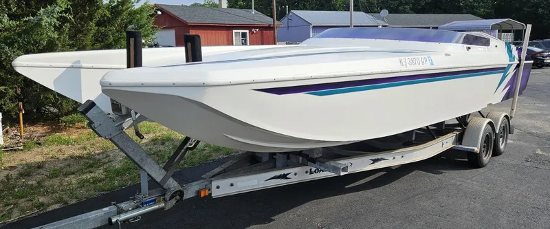 Slide: The Image of 2000 Eliminator 25 Daytona speedboat on trailer, white with purple and blue accents. - 16