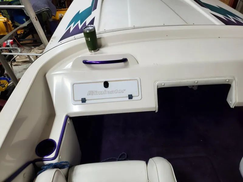 Slide: The Image of 2000 Eliminator 25 Daytona boat interior with cup holder and storage compartment. - 18