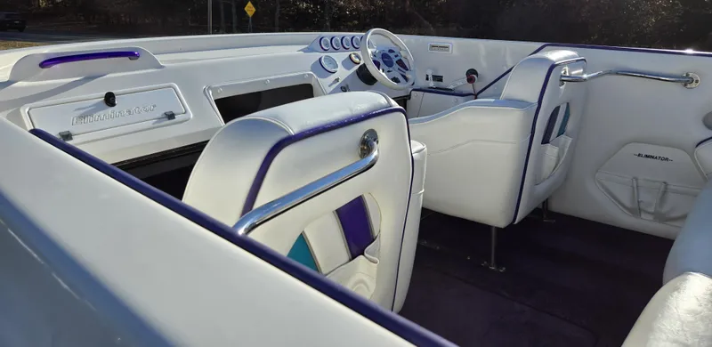 Slide: The Image of Interior of a 2000 Eliminator 25 Daytona boat with white and purple seating. - 24