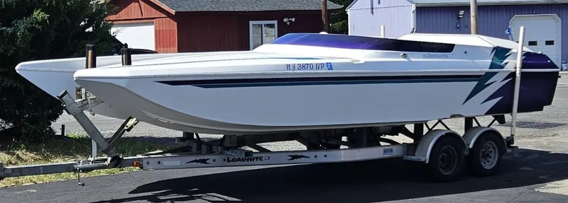 Slide: The Image of 2000 Eliminator 25 Daytona speedboat on trailer, parked outdoors. - 27
