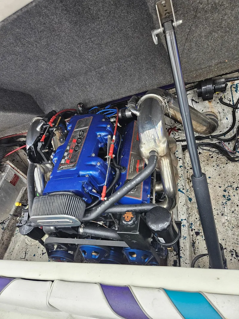 Slide: The Image of 2000 Eliminator 25 Daytona engine with blue components and chrome details in a boat compartment. - 7