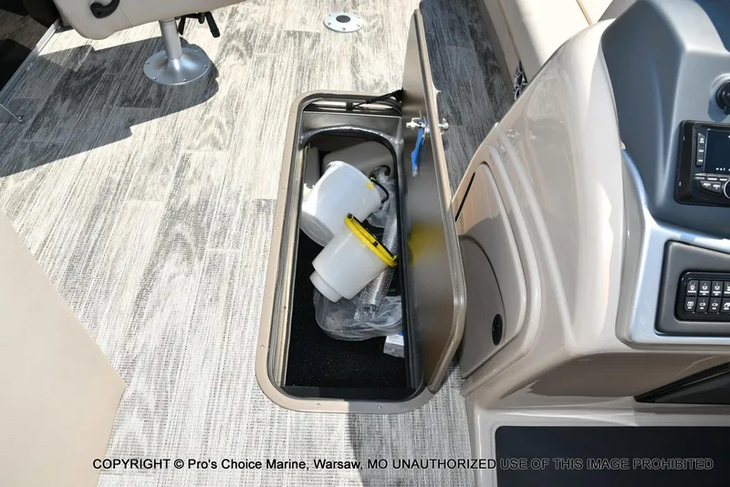 Slide: The Image of Open storage compartment on 2025 Ranger 223FC boat with interior items visible. - 35