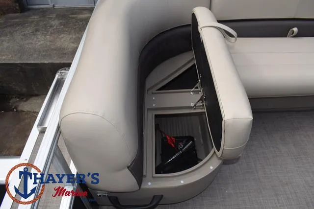 Slide: The Image of 2025 Sun Tracker PARTY BARGE® 16 DLX storage compartment with beige seating. - 19