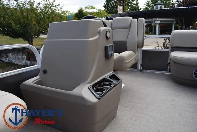 Slide: The Image of 2025 Sun Tracker PARTY BARGE® 16 DLX interior with seating and console, Thayer's Marine logo. - 20