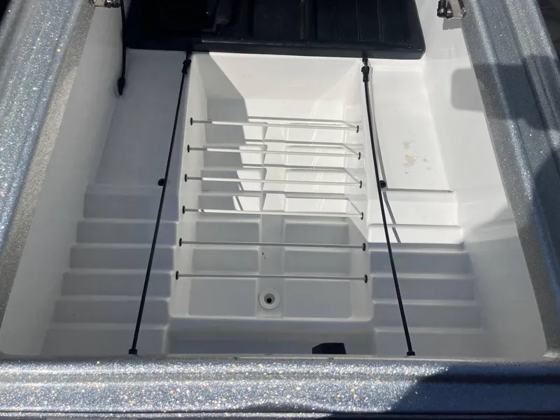 Slide: The Image of 2015 Phoenix 819 Pro boat storage compartment with bungee cords and drainage. - 16