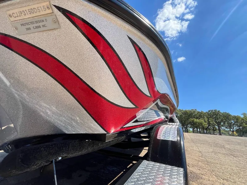 Slide: The Image of 2015 Phoenix 819 Pro boat with red flame design on trailer under blue sky. - 40