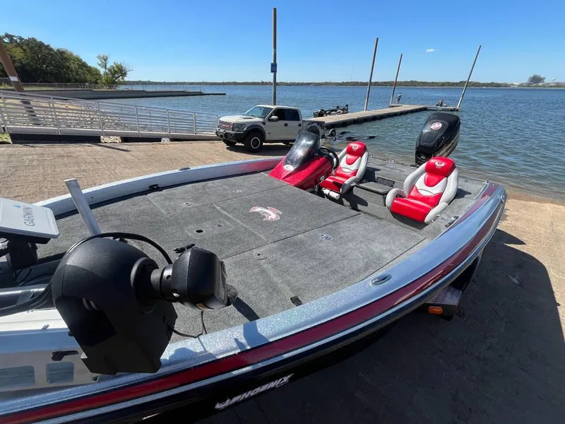 Slide: The Image of 2015 Phoenix 819 Pro boat at lakeside dock with red seats and motor. - 43