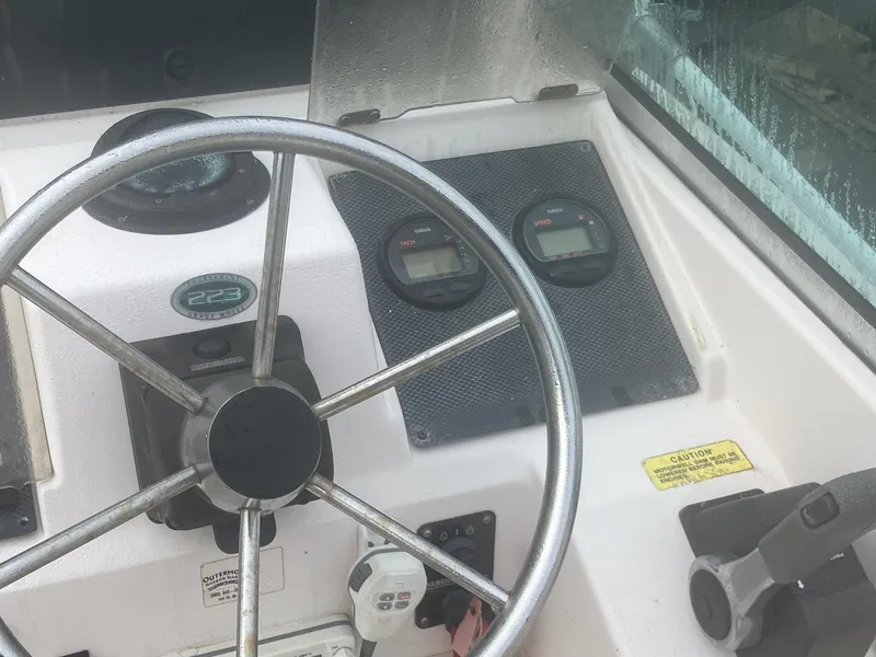 Slide: The Image of Steering wheel and dashboard of a 2002 Grady-White 22 boat. - 2