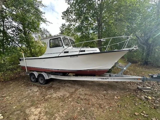 Slide: The Image of 2007 Eastern Pilothouse boat on trailer in wooded area. - 2