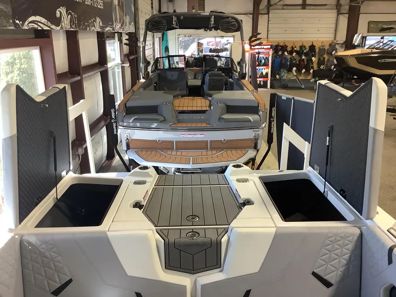 Slide: The Image of 2025 Nautique GS22 boat interior with open storage compartments in showroom. - 14