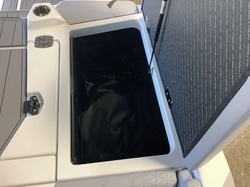 Slide: The Image of 2025 Nautique GS22 boat storage compartment with open lid, showcasing interior space. - 16