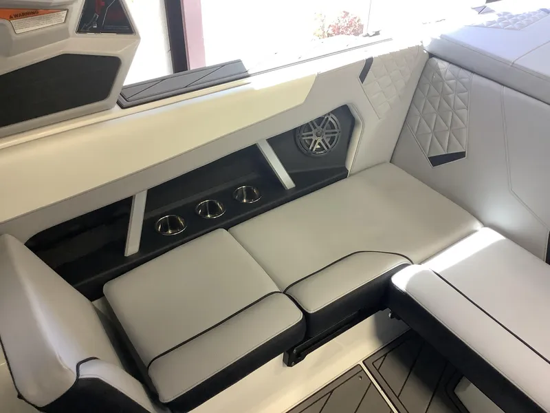 Slide: The Image of 2025 Nautique GS22 interior seating with cup holders and speaker system. - 19