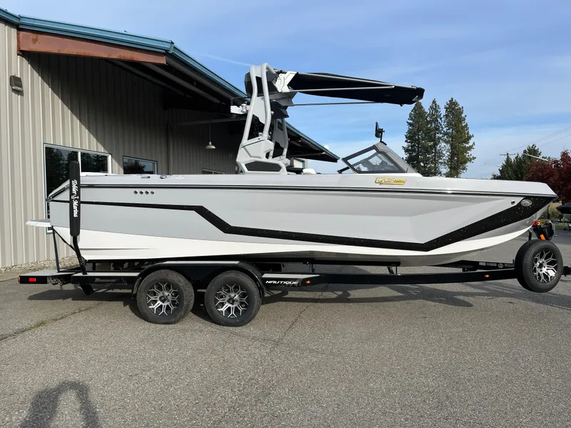 Slide: The Image of 2025 Nautique GS22 boat on trailer, parked outside a building. - 3