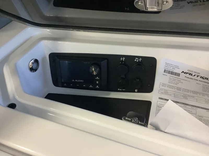Slide: The Image of 2025 Nautique GS22 audio system and control panel with order documents. - 5