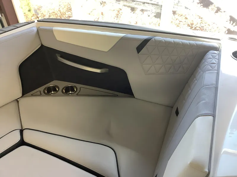 Slide: The Image of 2025 Nautique GS22 interior seating with cup holders and stylish upholstery. - 7