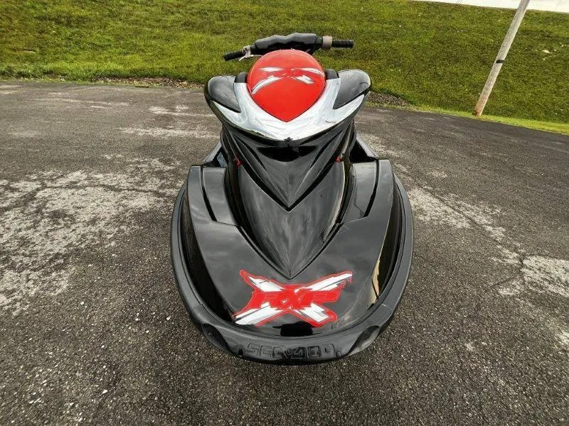Slide: The Image of 2011 Sea-Doo RXP 255 jet ski, black and red, parked on asphalt. - 12