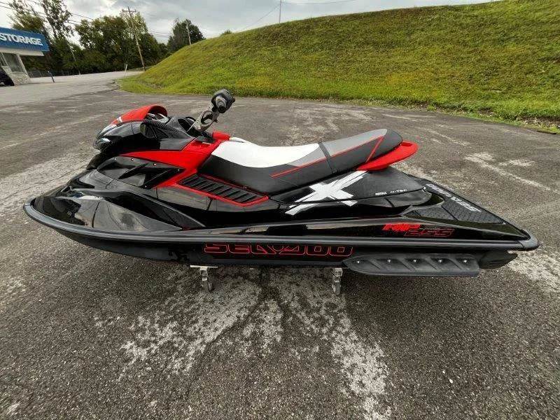 Slide: The Image of 2011 Sea-Doo RXP 255 jet ski, black and red, parked on asphalt. - 29